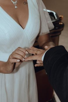 Close-up of a bride and groom exchanging wedding rings during their ceremony.