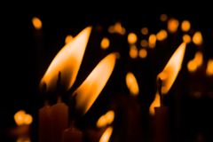 Warm candle flames creating a peaceful, reflective atmosphere in darkness.