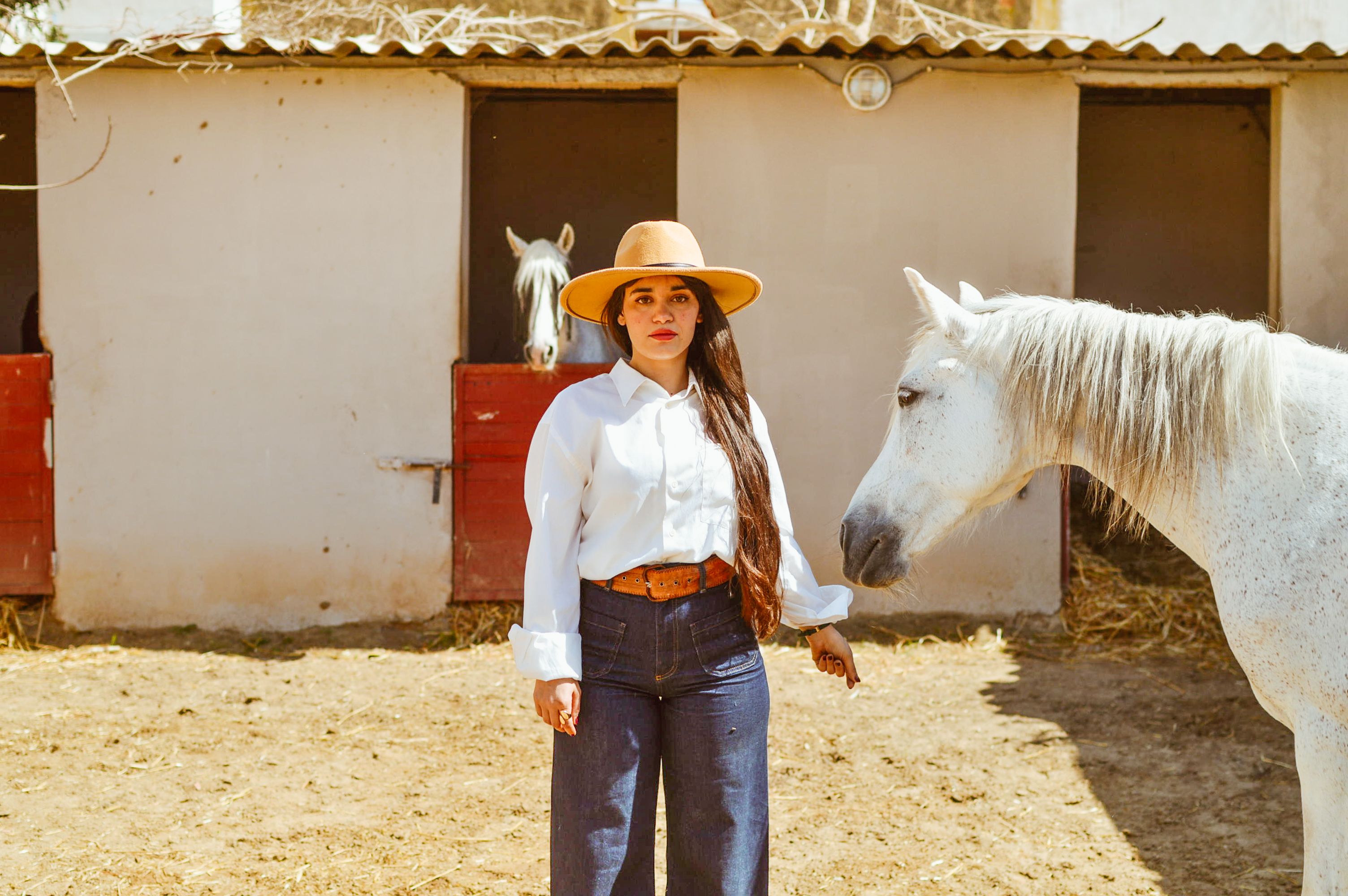 Woman in Ranch Attire with White Horse Outdoors · Free Stock Photo