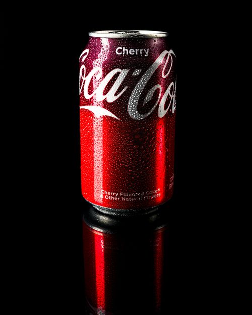 Free Close-up of a dew-covered cherry soda can on a reflective surface. Stock Photo
