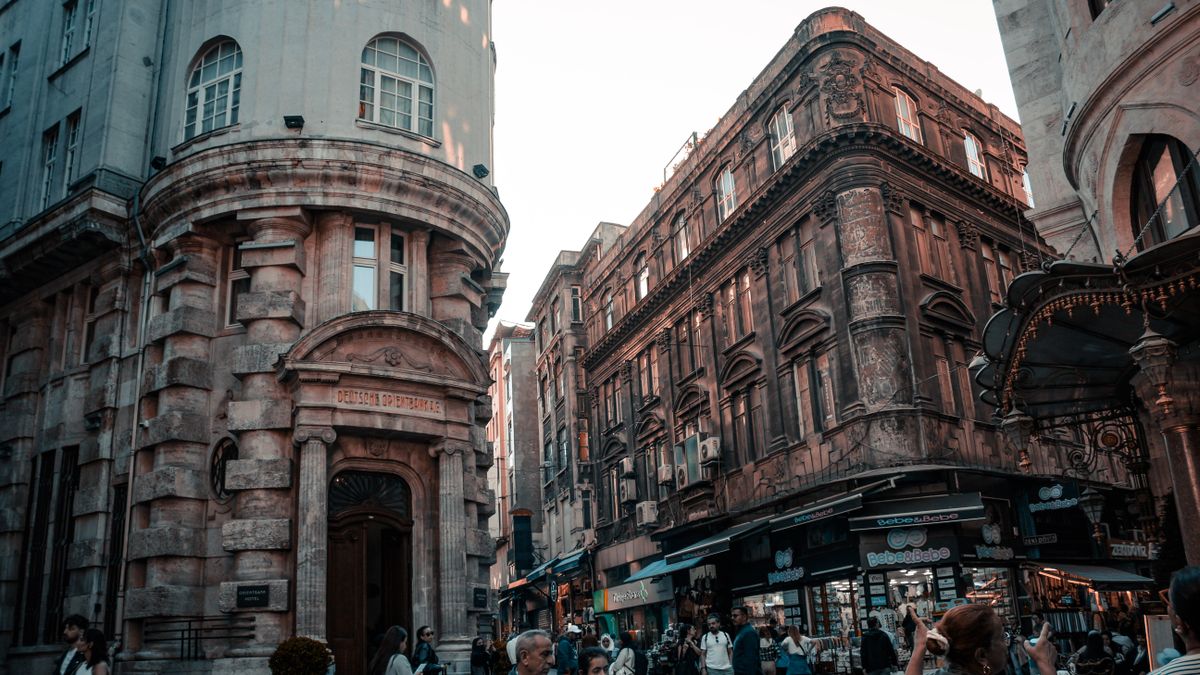 A busy street with historic European buildings and people passing by, showcasing urban lifestyle.