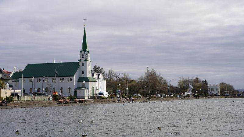 Tjörnin lake with a green-roofed church on the shore in Reykjavik