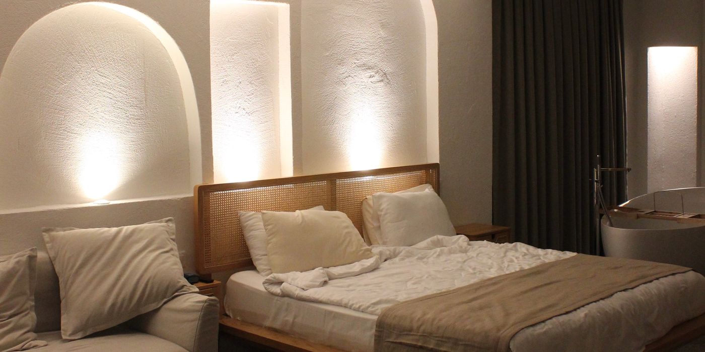 A warmly lit mid-range hotel room with modern furnishings and soft lighting