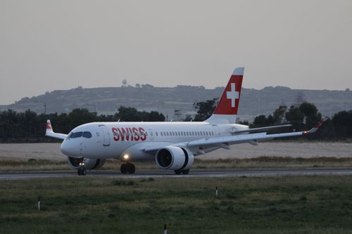 Free Swiss airplane preparing for takeoff during twilight on a runway. Stock Photo