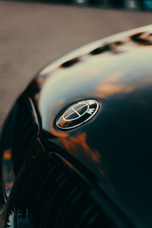 Free Reflective car hood capturing a vibrant sunset sky, highlighting the vehicle's sleek design. Stock Photo