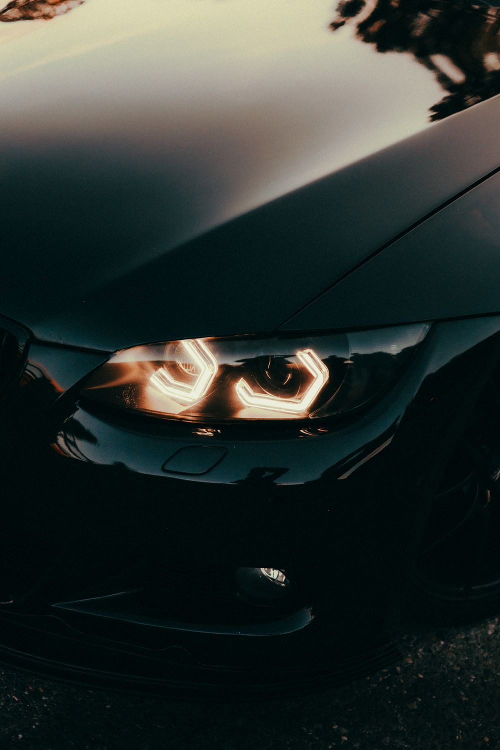 Luxury car headlights glowing at dusk
