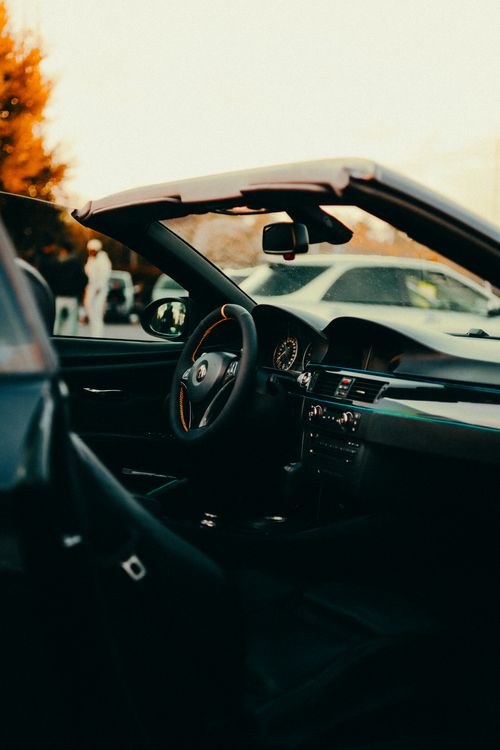 Free Interior of a luxury convertible car at sunset, showcasing the steering wheel and dashboard. Stock Photo