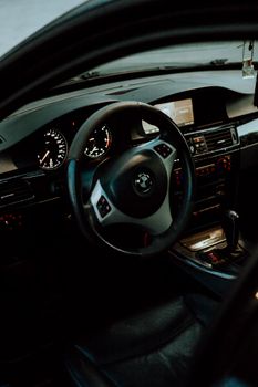 Detailed view of a car interior featuring a steering wheel, dashboard, and gear shift.