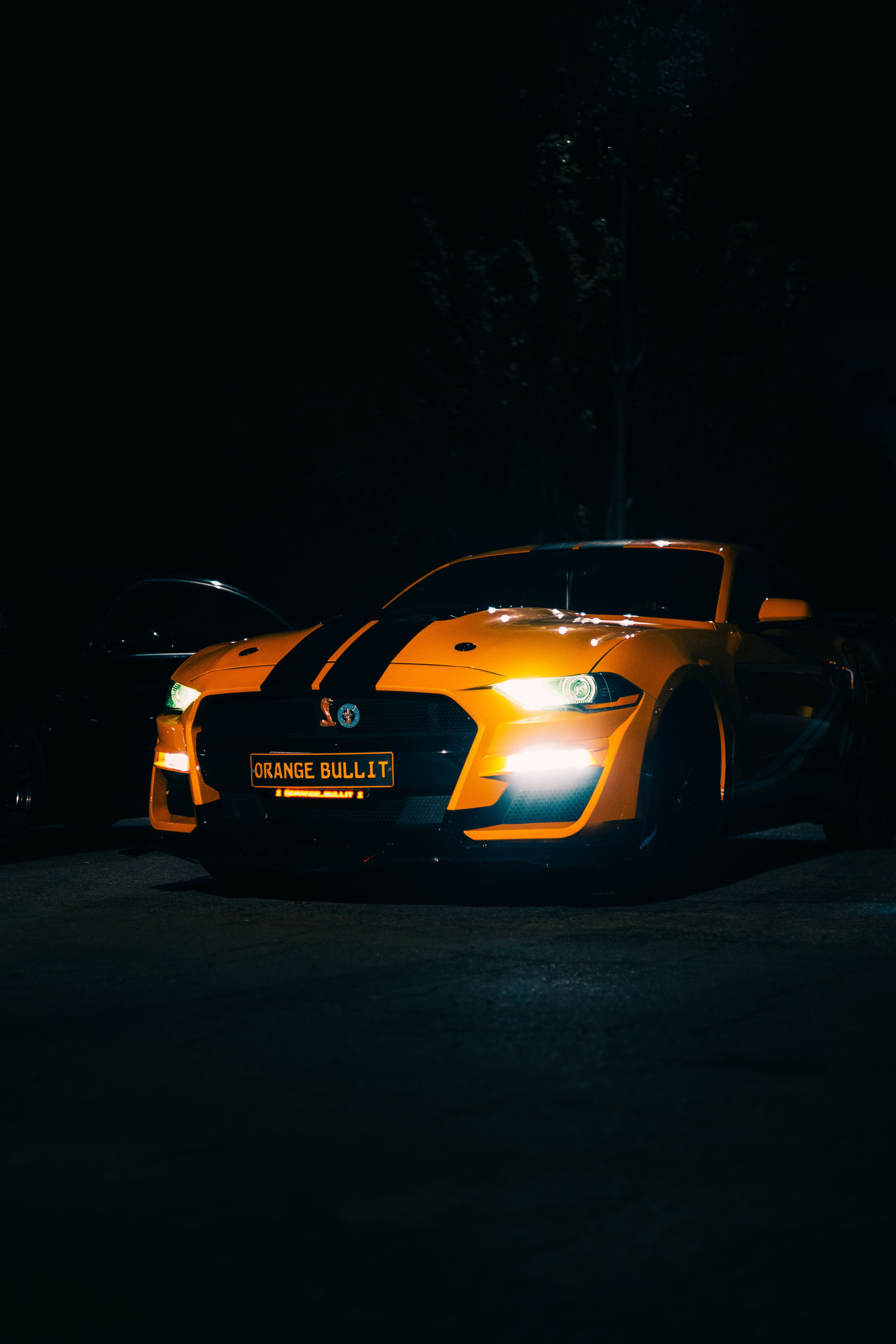 Orange Sports Car with Racing Stripes at Night · Free Stock Photo