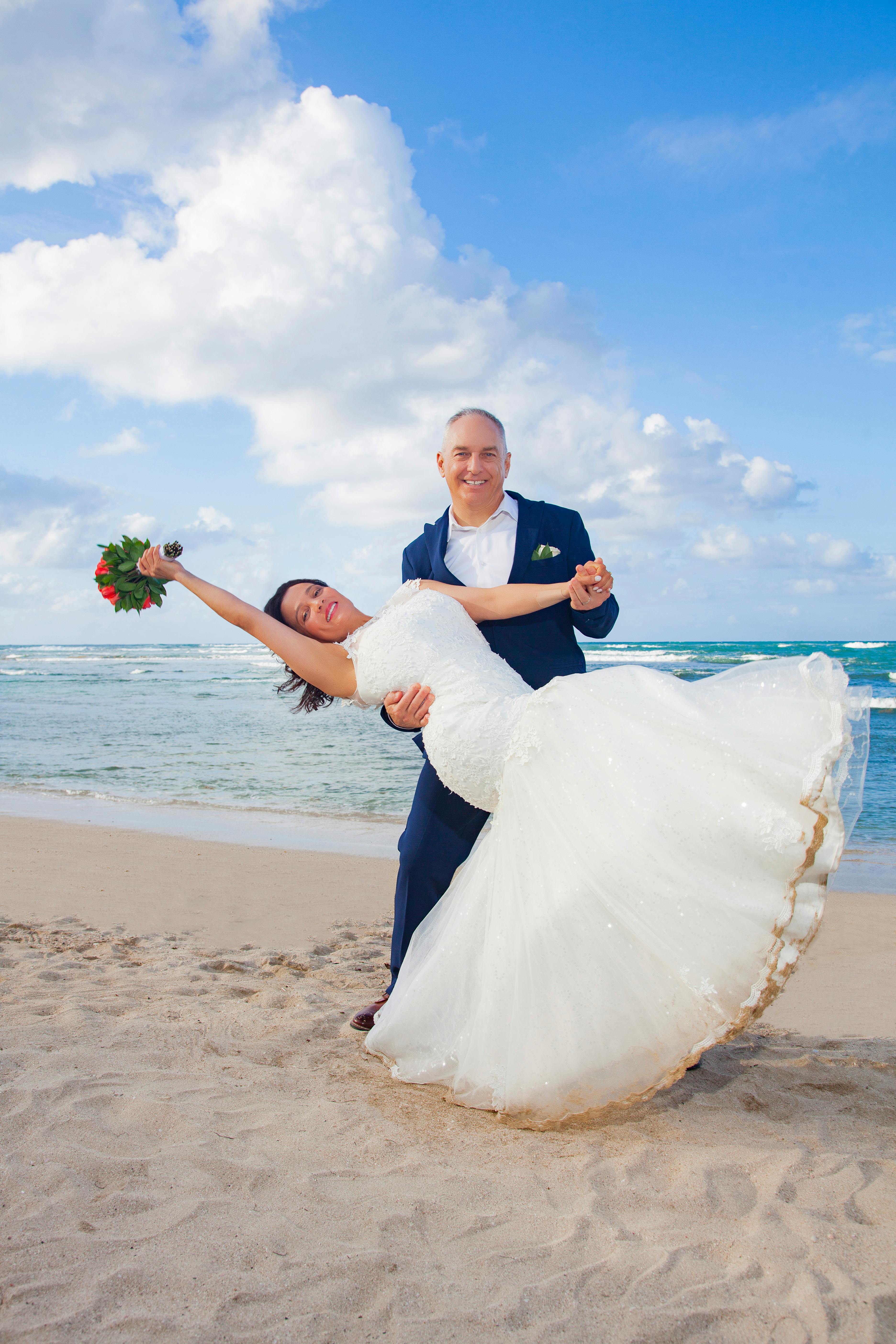 Joyful couple dancing on a beach in Puerto Plata. Perfect for romantic and destination wedding themes.