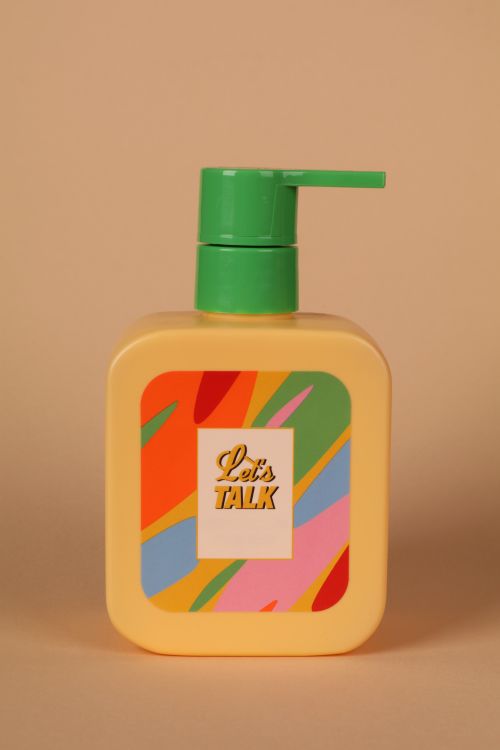 Free Vibrant plastic soap dispenser with colorful design and 'Let's Talk' label on neutral background. Stock Photo
