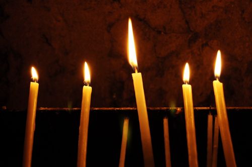 Free Lit candles creating a warm ambiance in Jerusalem's sacred setting. Stock Photo