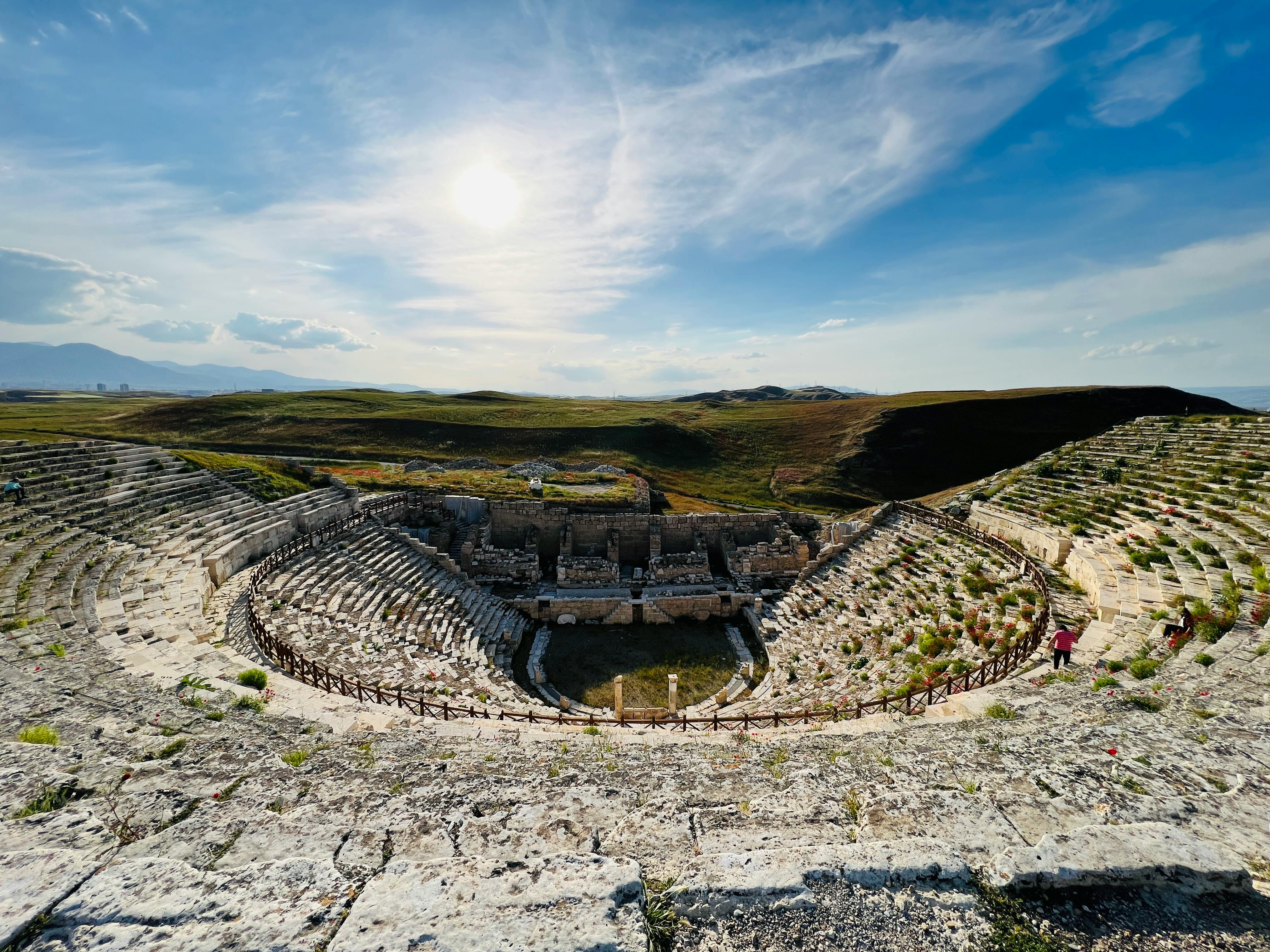 Kostenlos Ein atemberaubender Blick auf ein antikes römisches Amphitheater mit sonniger Kulisse und offener Landschaft. Stock-Foto