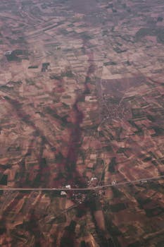 Photo by Ali S Aerial view of diverse farmland patterns showcasing a patchwork landscape.