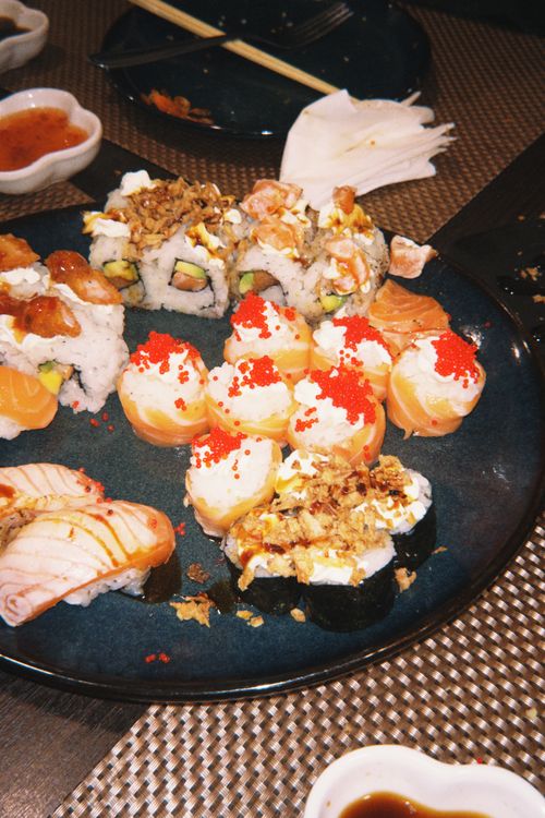 Free Colorful assortment of sushi rolls on a blue plate, perfect for food enthusiasts and Japanese cuisine lovers. Stock Photo