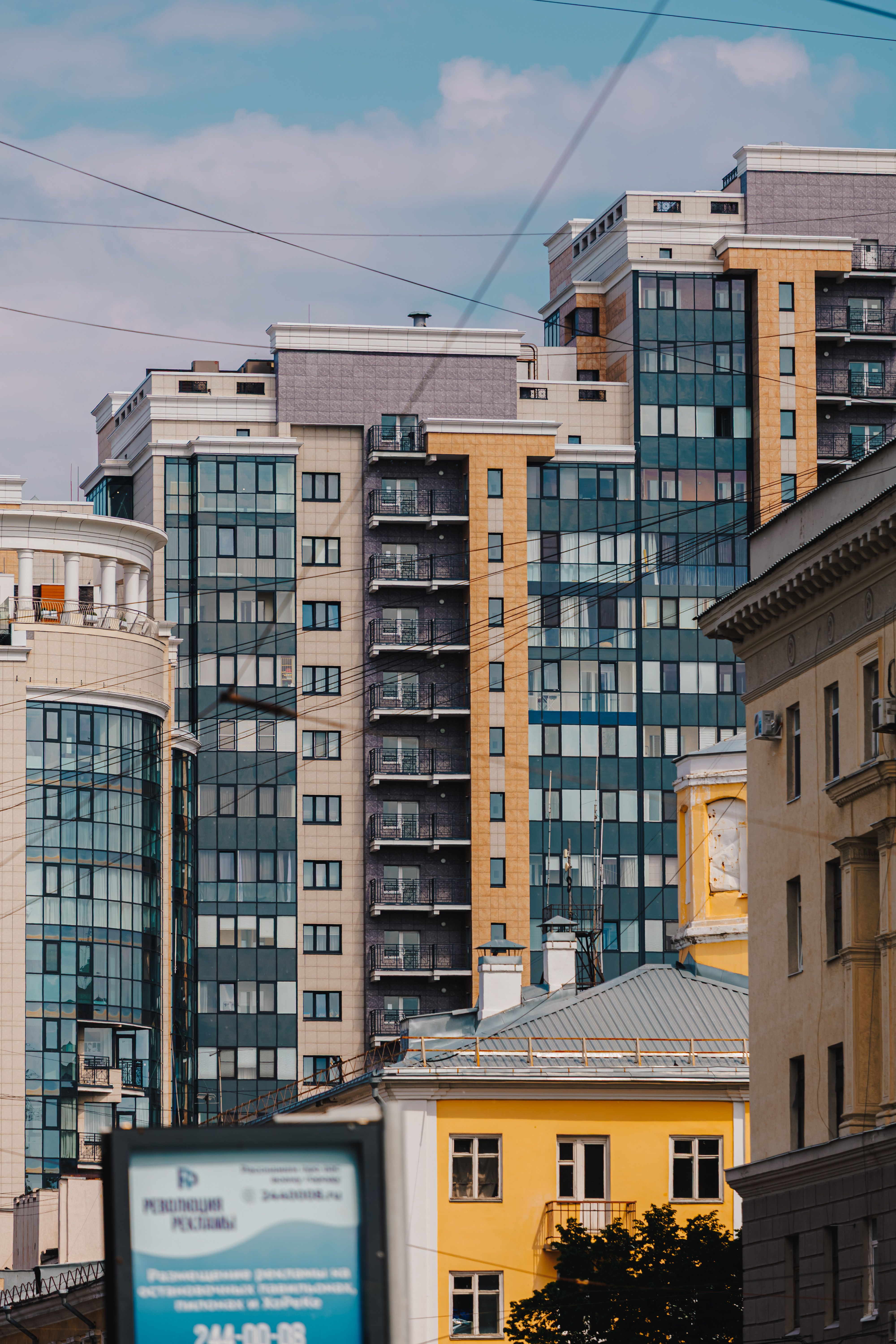 Fotomural Una vista de imponentes edificios urbanos modernos bajo un cielo azul que muestra la arquitectura contemporánea.