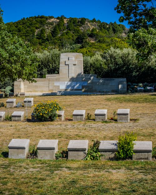 Free War cemetery with headstones and memorial against scenic outdoor backdrop on a sunny day. Stock Photo