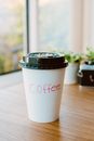 特写：室内木桌上的一次性咖啡杯