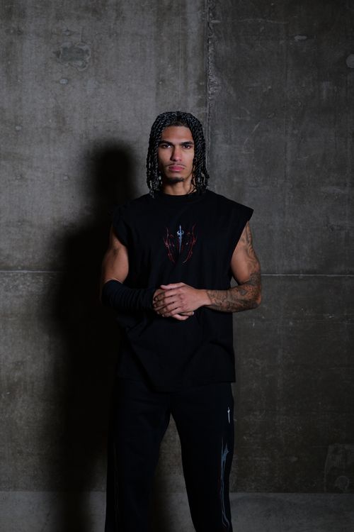 Free Stylish man in urban environment wearing dark fashion attire against concrete wall. Stock Photo