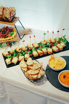 Delicious assortment of sandwiches and dips on a buffet table, perfect for events.