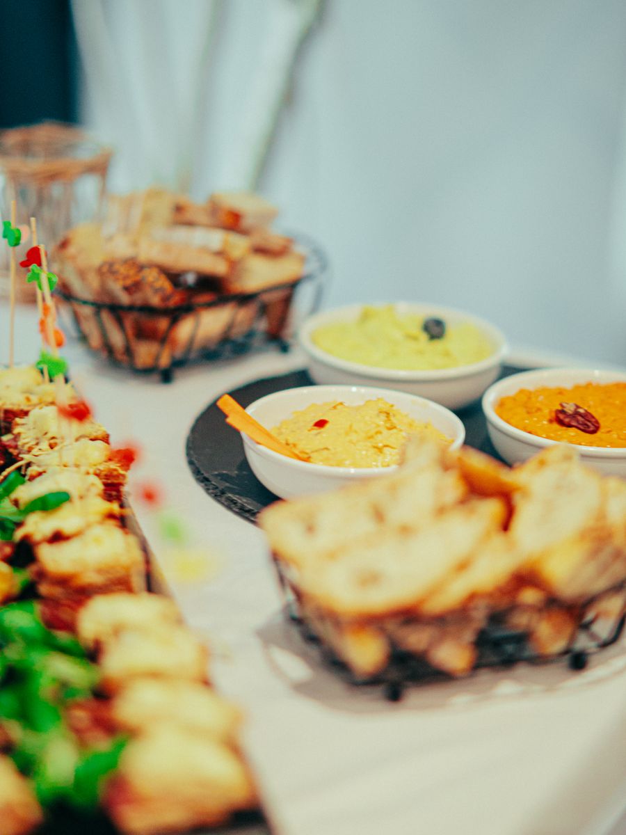 Mesa buffet con dips, pan y entradas variadas.