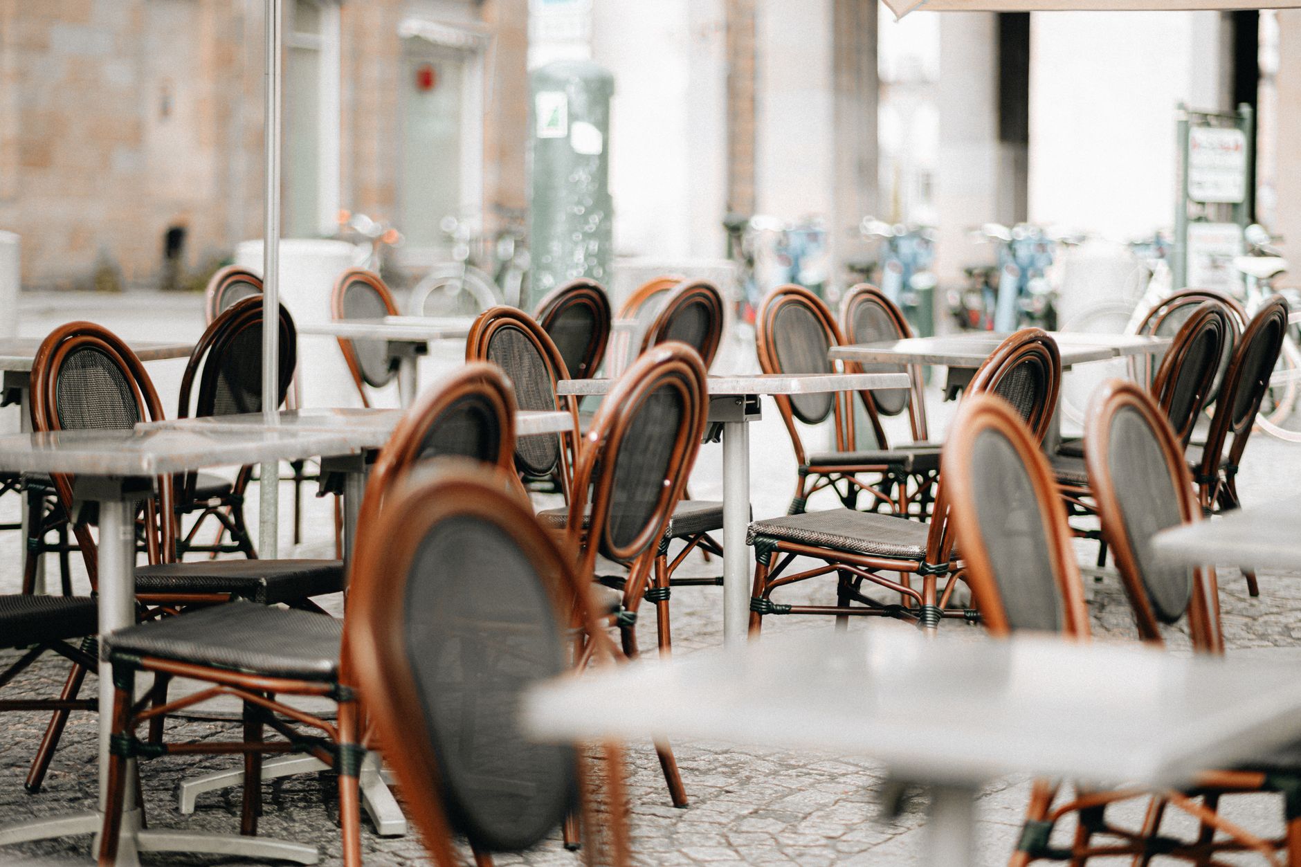 Empty wicker chairs and tables at an outdoor cafe