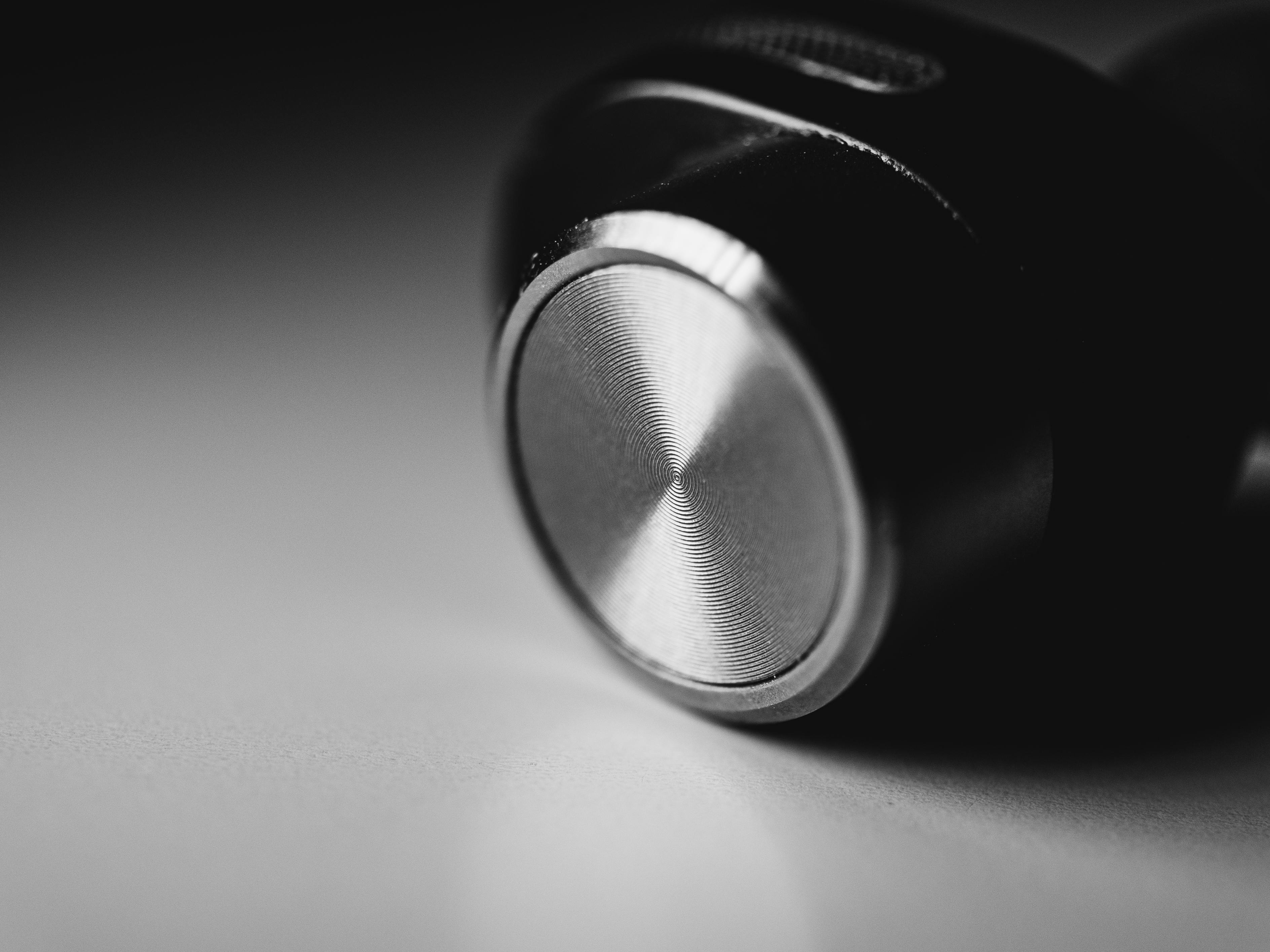 Gratis Bidikan makro close-up dari earbud berwarna hitam dan perak yang menampilkan lapisan metalik yang ramping. Foto Stok