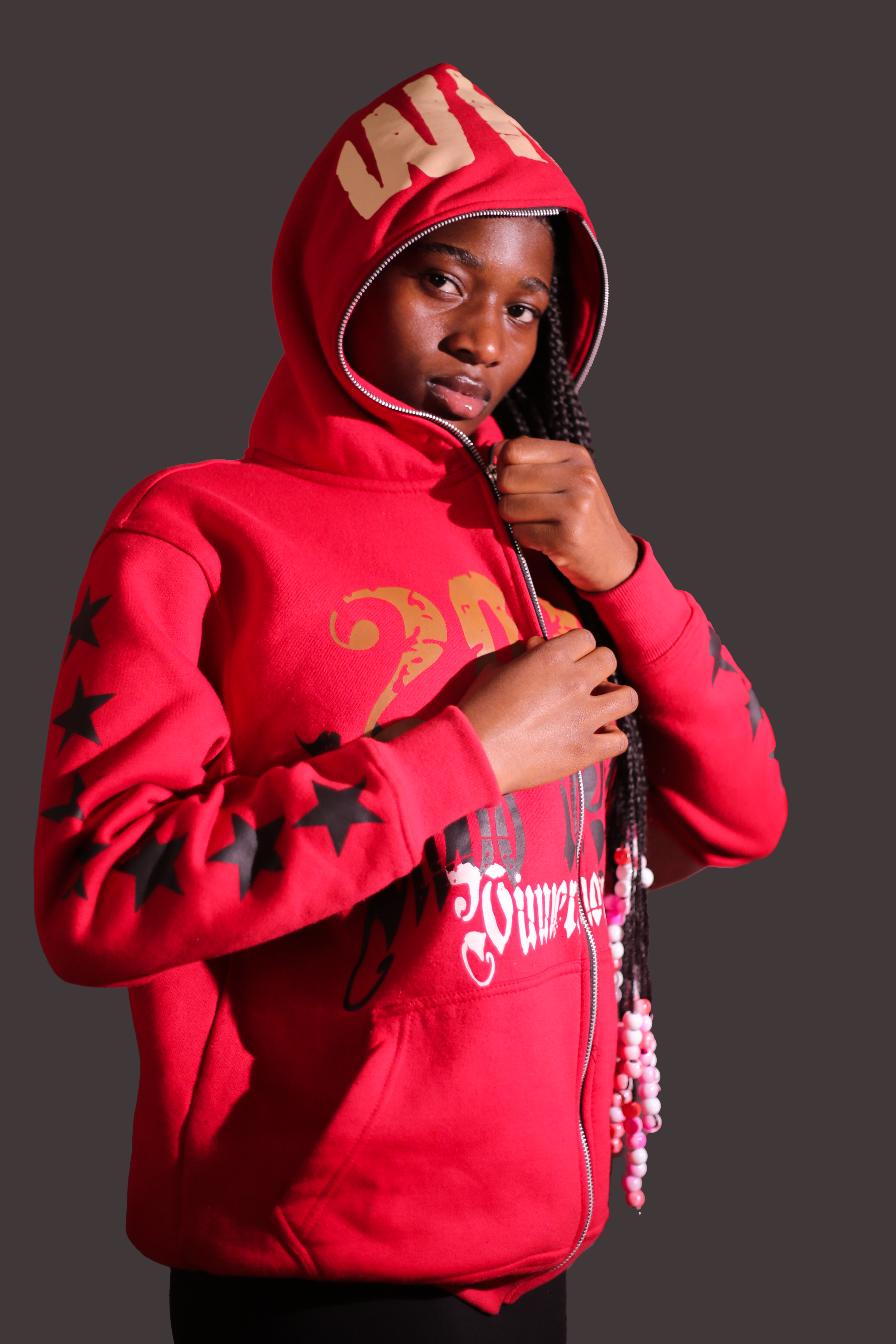 Portrait of a young woman wearing a red hoodie with unique graphic designs, focusing on style and fashion.