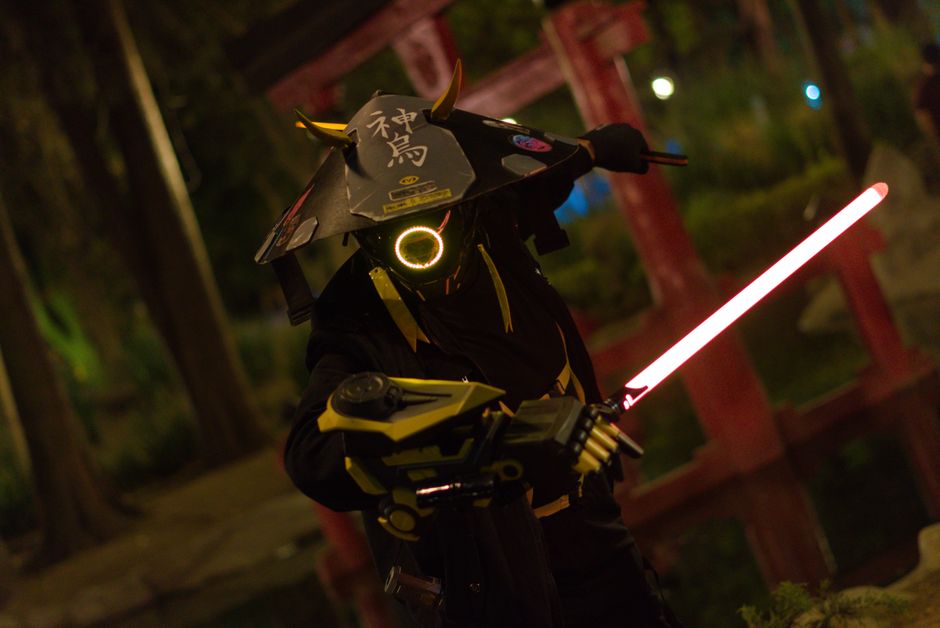 A captivating image of a futuristic samurai warrior cosplay illuminated by neon lights in a night environment.