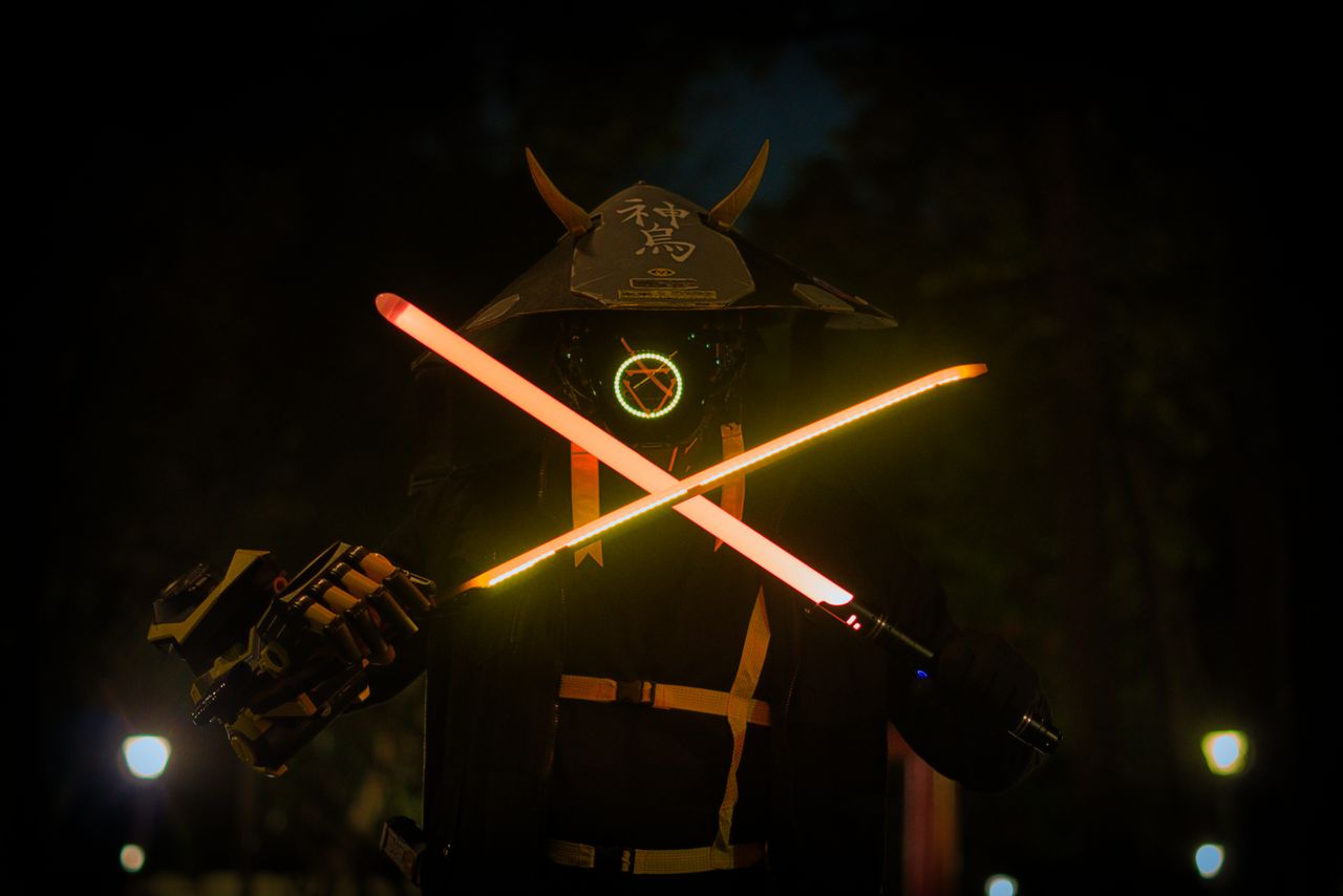 a futuristic samurai in a helmet and mask holding glowing neon swords