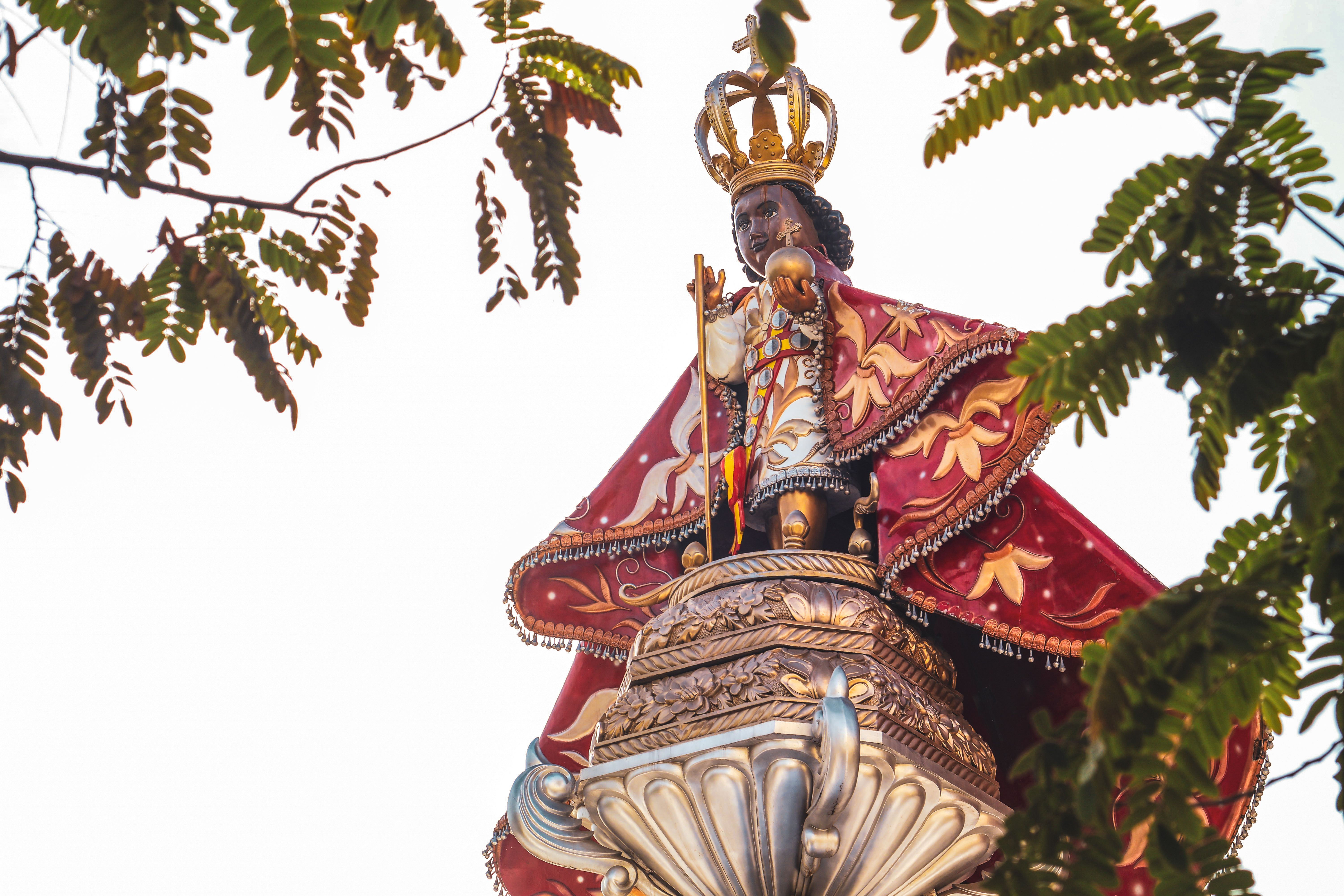 Dramatic Statue of Crowned Figure Amidst Leaves · Free Stock Photo