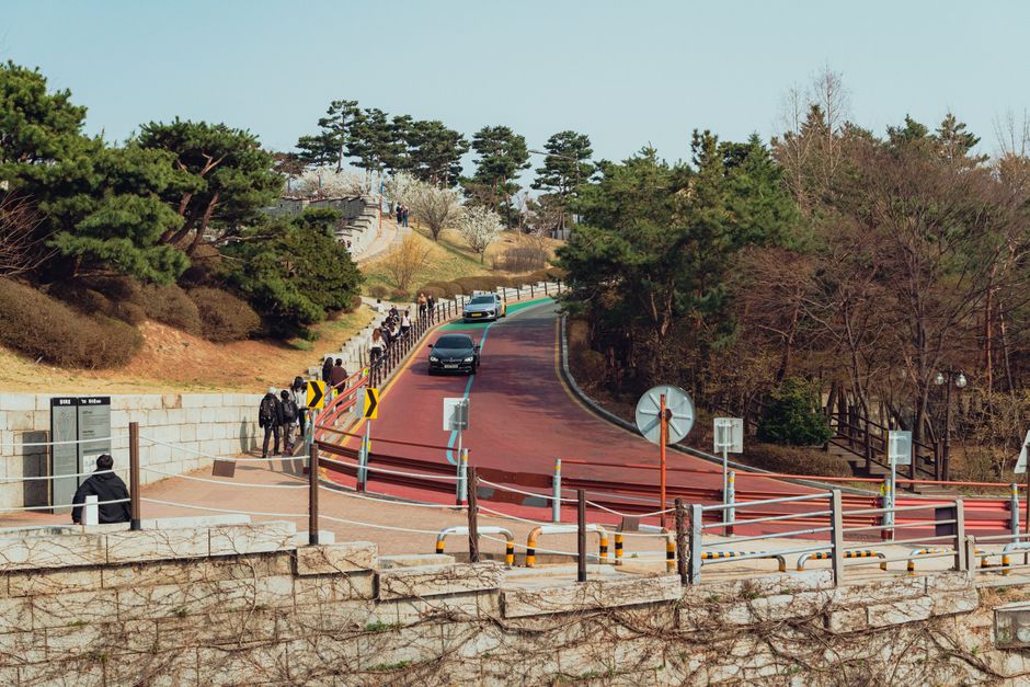 A vibrant street scene in Suwon, South Korea with people strolling by in spring.