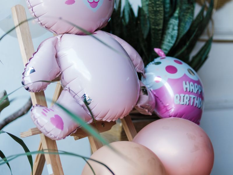 Pink teddy bear balloon with birthday balloons