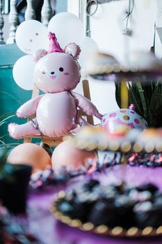 Charming pink teddy bear balloon adds joy to outdoor children's party with festive decorations.