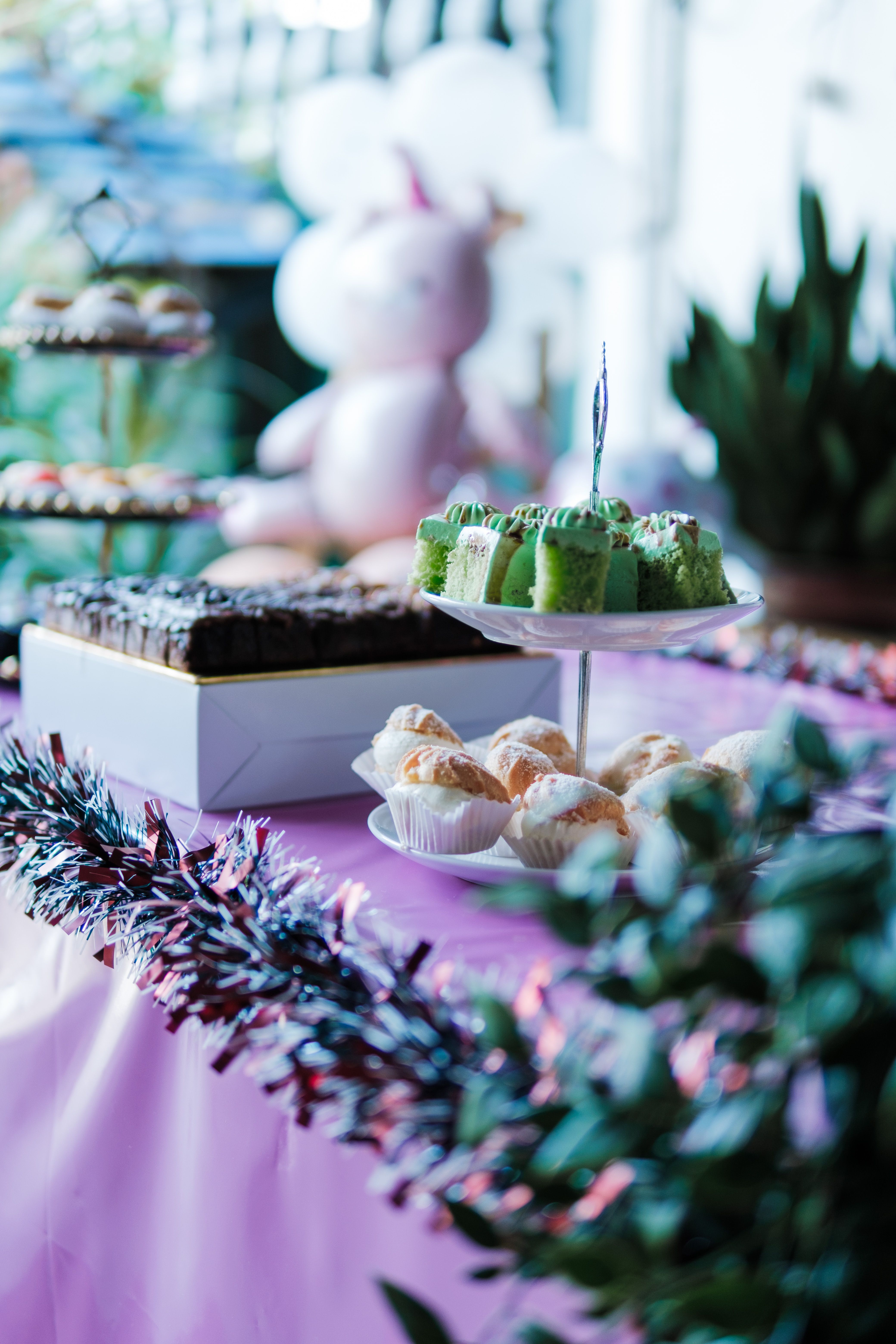 Party table with colourful cakes, pastries and decorations