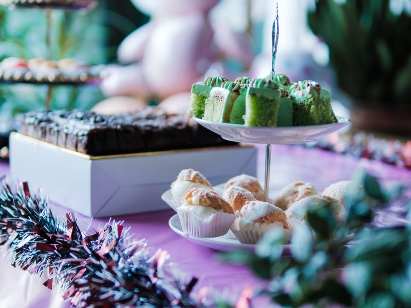 Party table with colourful cakes, pastries and decorations