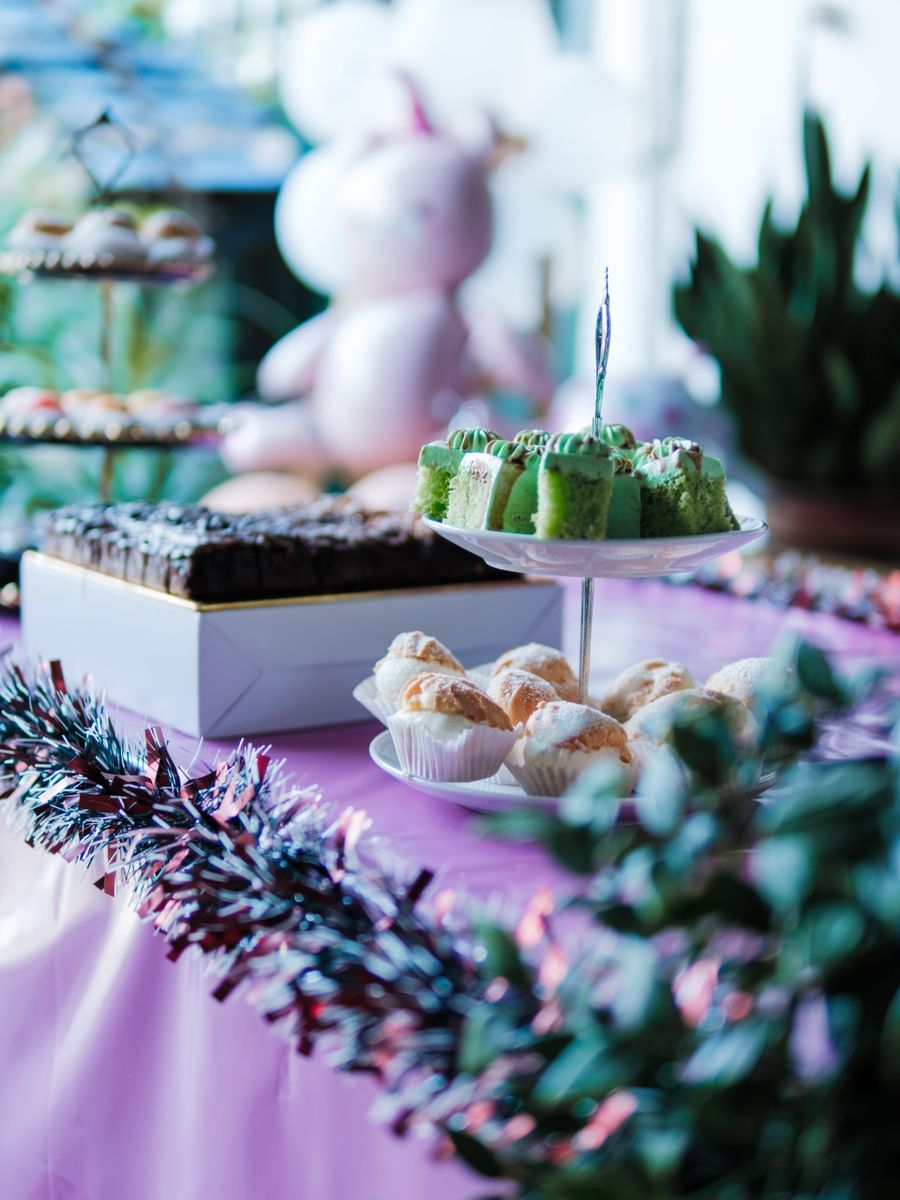 Mesa de fiesta con tortas, pastelería y decoración colorida.