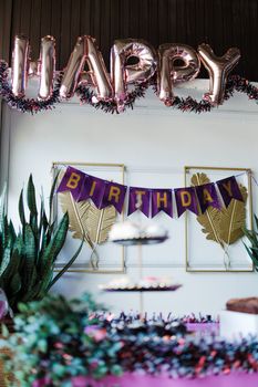 Colorful birthday party setup with balloons and festive banners indoors.