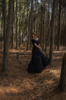 Artistic capture of a woman in black dress twirling in a serene pine forest.