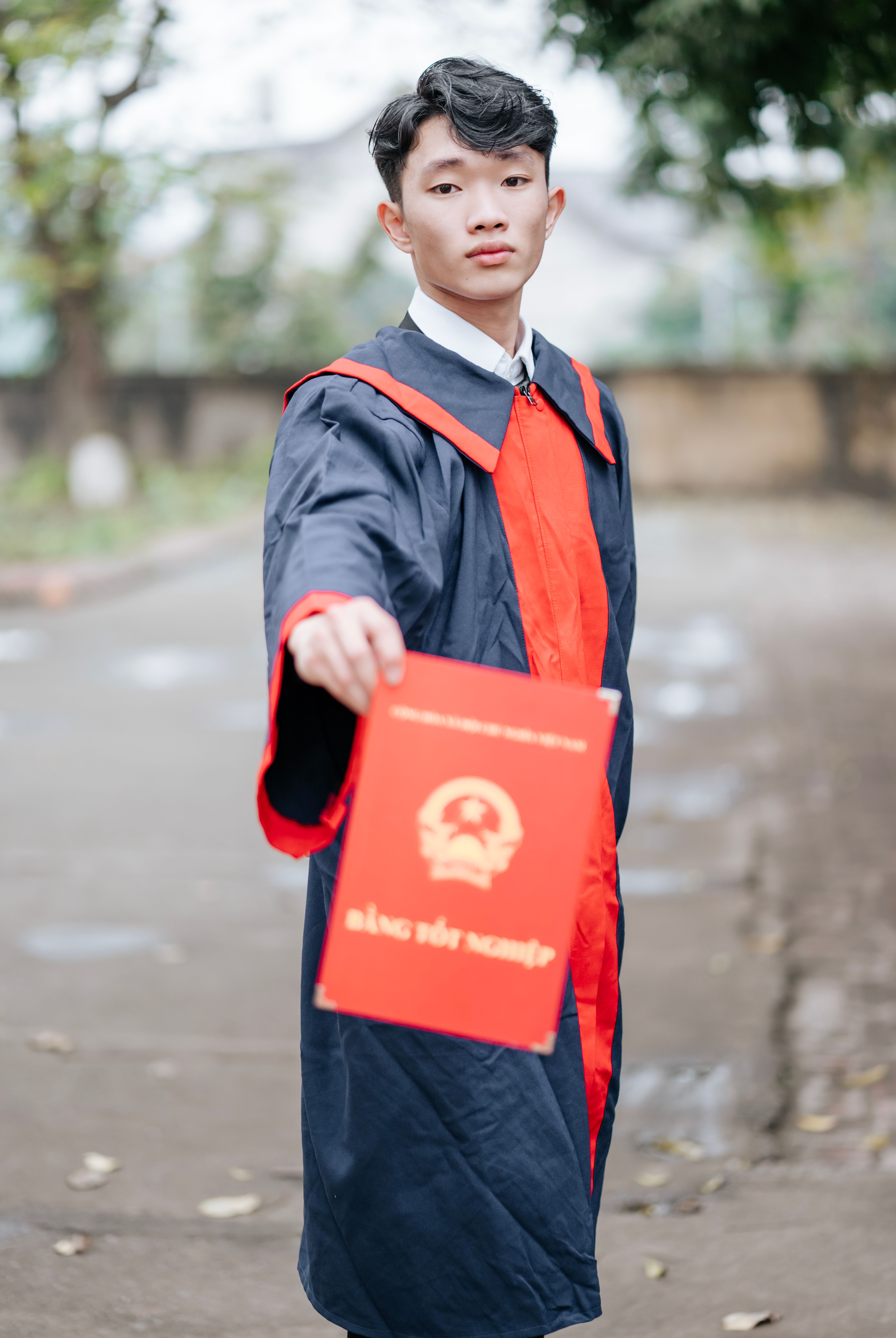 Close-Up Shot of a Person Holding Square Academic Cap and Diploma ...
