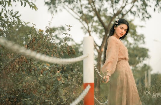 一位美丽的女人身着柔软飘逸的连衣裙，在风景优美的户外优雅地摆着姿势