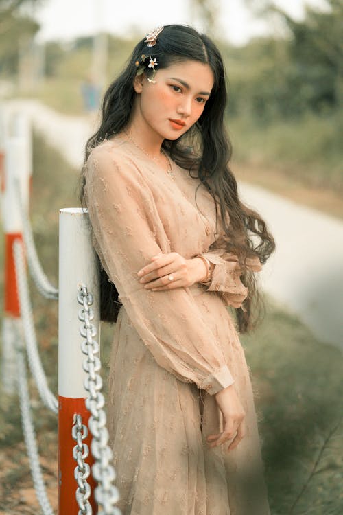 Selective Focus Photo of Woman Standing Near Metal Fence