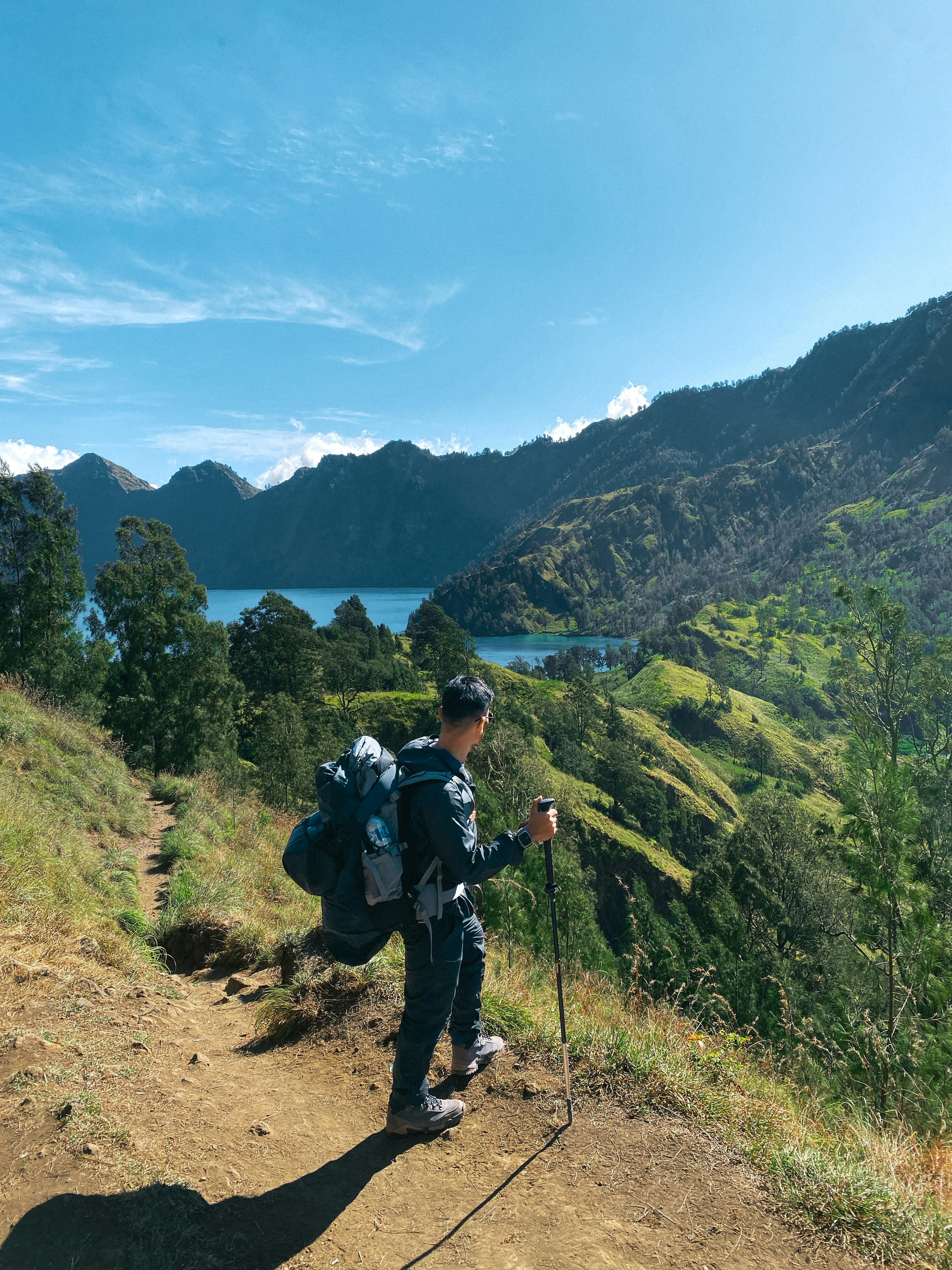 A person with ultralight hiking gear and trekking poles.