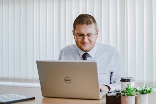 Man in White Dress Shirt Using Silver Dell Laptop