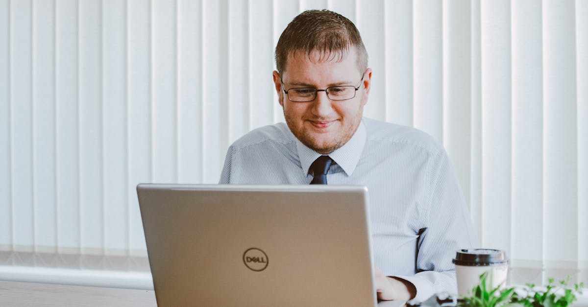 Photo by Lisa from Pexels Business professional working on laptop at office desk with coffee and plants.