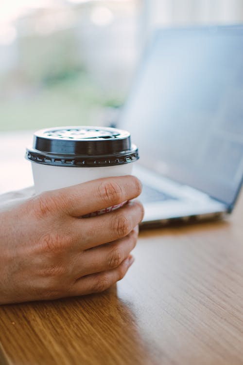 Person Holding White Disposable Cup