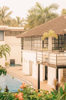 Beautiful tropical resort with pool, palm trees, and traditional architecture.