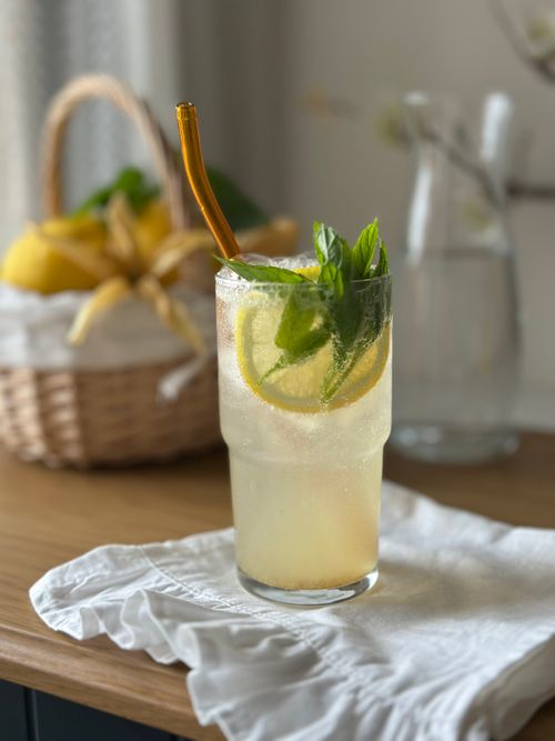 Free A fresh lemonade with basil garnished in a glass on a wooden table, ideal for summer refreshment. Stock Photo