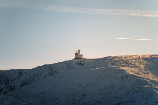 A stunning view of the Sniezne Kotly Observatory in Karkonosze National Park during sunrise.