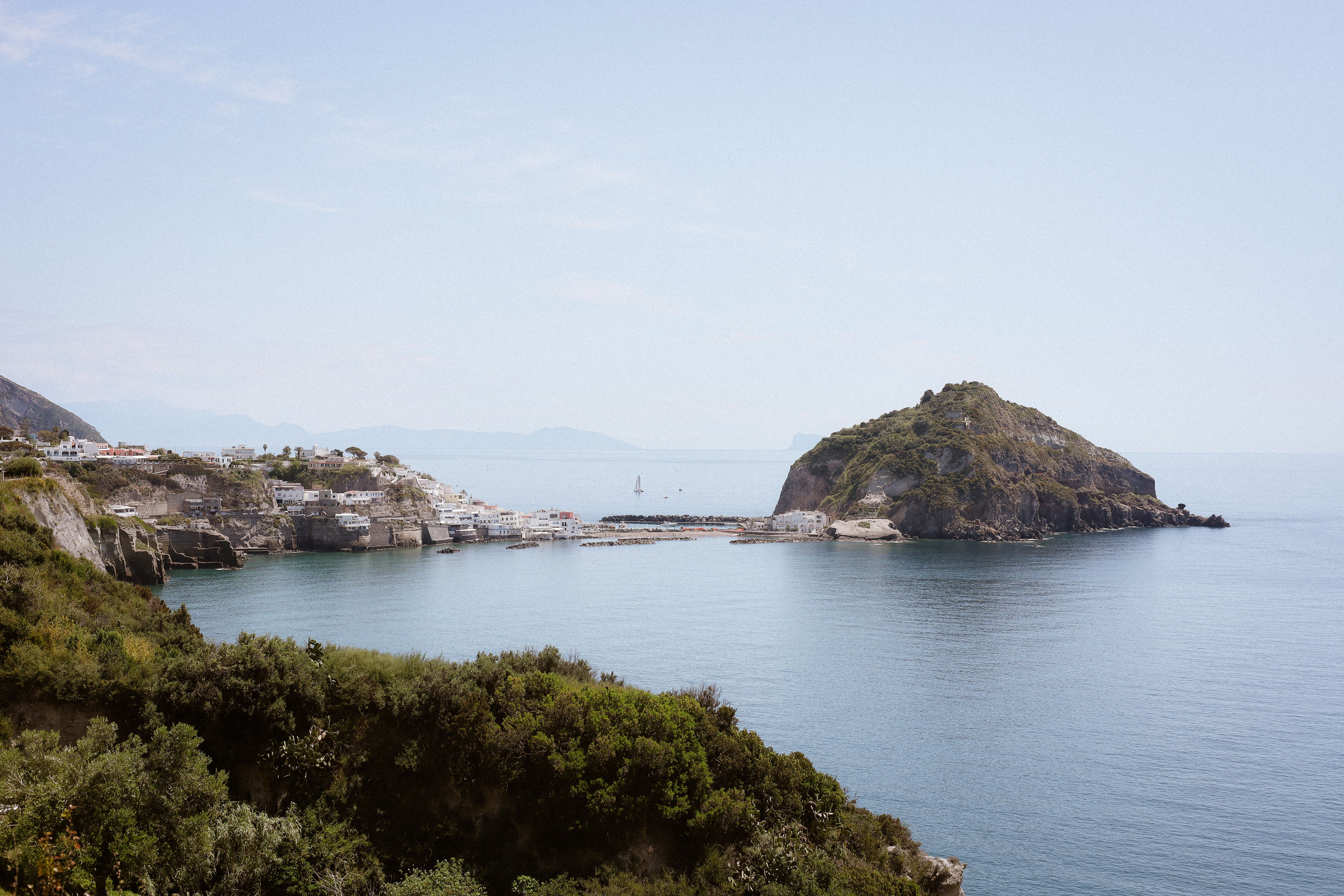 Picturesque view of Sant'Angelo village with a serene sea and lush greenery.